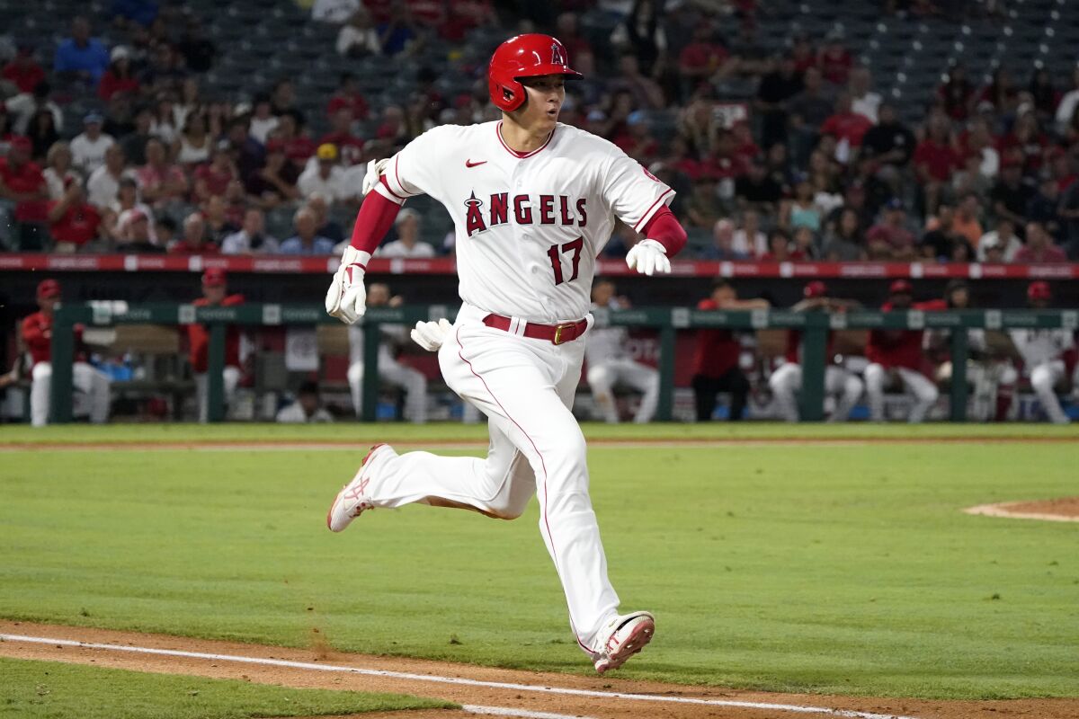 Angels' Shohei Ohtani runs to first base as he grounds out.