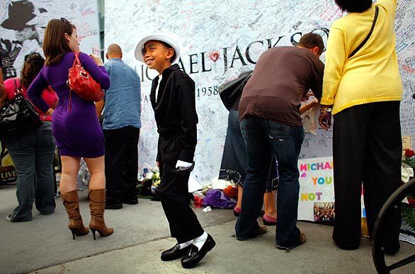 Anthony Angel, 8, of Los Angeles, poses for his mom, Michelle Javellana, in front of a board where fans could leave notes outside Staples Center.