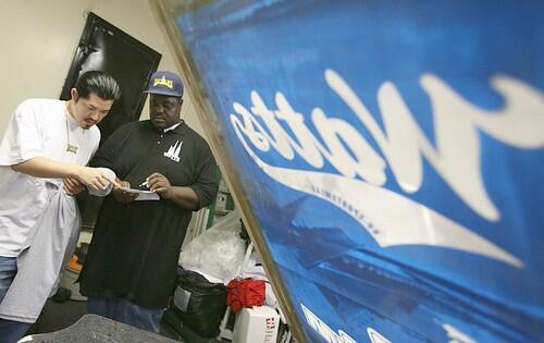 AVID CUSTOMER: Uji Ota, left, president of the One O Five car club in Nagano, Japan  its named after L.A.s 105 Freeway  goes over an order with Jordan. He bought more than $1,000 in clothing with the Wattslife logo.