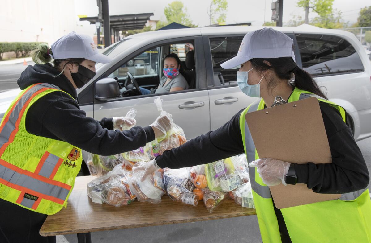 Volunteers help hand out bags of food at a distribution site in San Fernando.