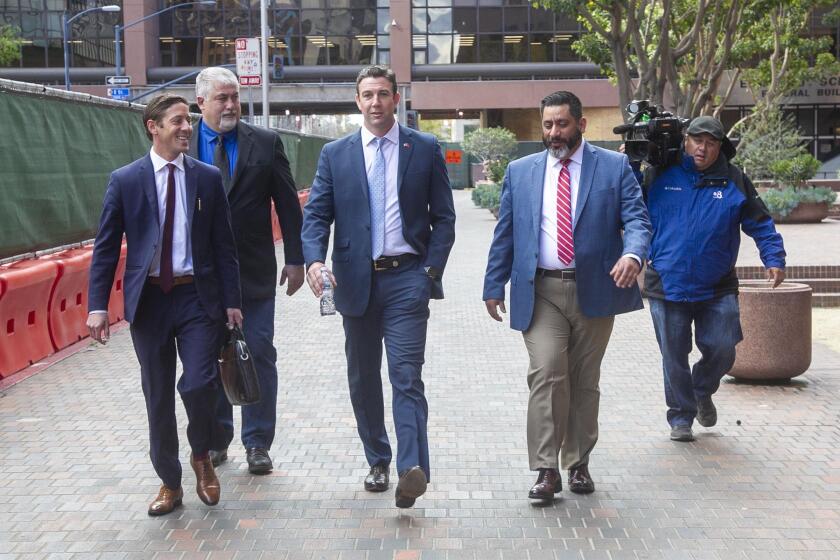 Former US Representative Duncan Hunter, center, walks towards Broadway after leaving through the back door of the Federal courthouse in San Diego, CA on March 17th after being sentenced to 11 months in Federal Prison after pleading guilty to a single count related to campaign fraud.