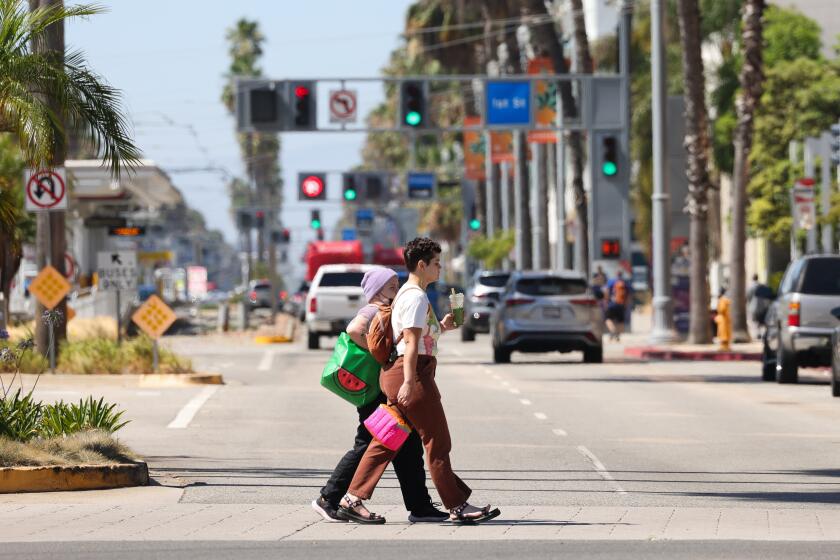 LONG BEACH-CA-JULY 3, 2024: Pedestrians walk along Ocean Boulevard in Long Beach on July 3, 2024. (Christina House / Los Angeles Times)