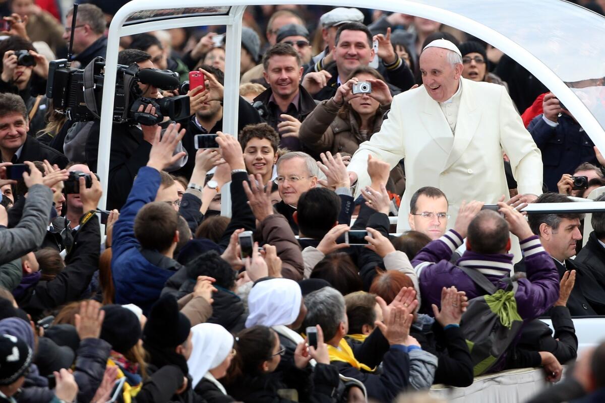 Pope Francis waves to the crowds as he arrives in St. Peter's Square in the Vatican City for his weekly audience.