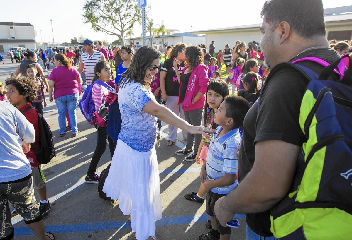 Suzanne Berkers, a third-grade teacher at Oak View Elementary School, talks with students and parents last week on the day Ocean View School District started to bus students from that campus and two others to surrounding districts because of asbestos concerns.