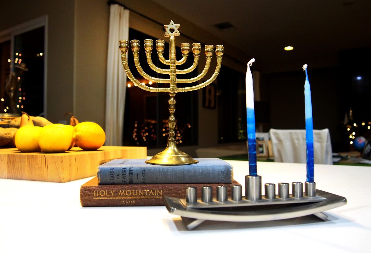 Hanukkah menorahs are seen on a table.