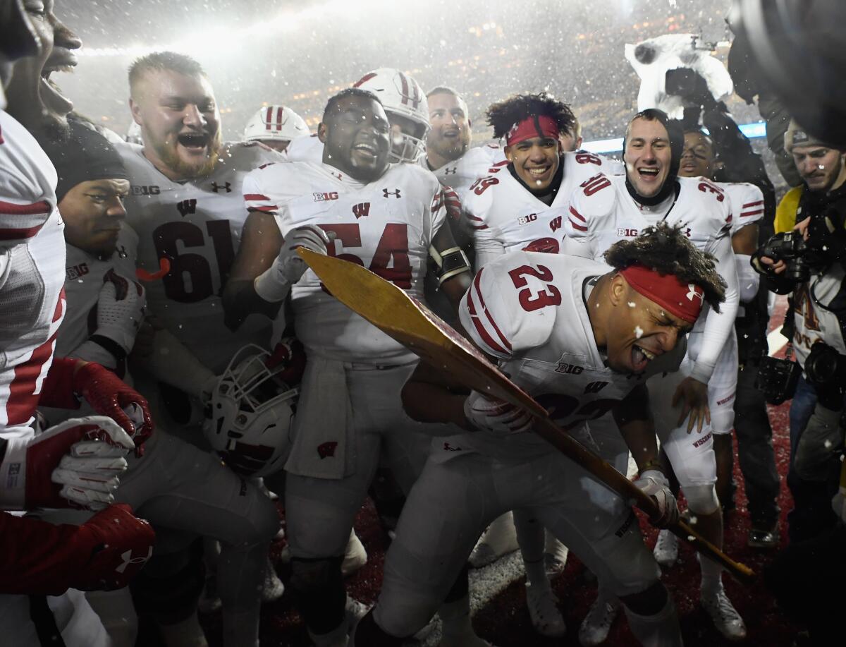Wisconsin's Jonathan Taylor celebrates with the Paul Bunyan Axe trophy.