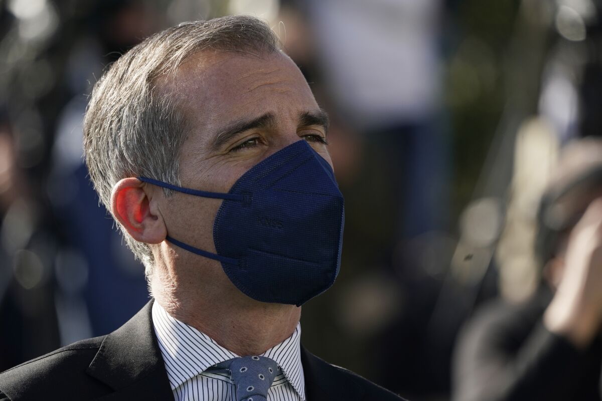 Los Angeles Mayor Eric Garcetti wears a mask as he listens to fellow speakers at a news conference near SoFi Stadium, site of the NFL football Super Bowl later this month, Wednesday, Feb. 2, 2022, in Inglewood, Calif. (AP Photo/Marcio Jose Sanchez)