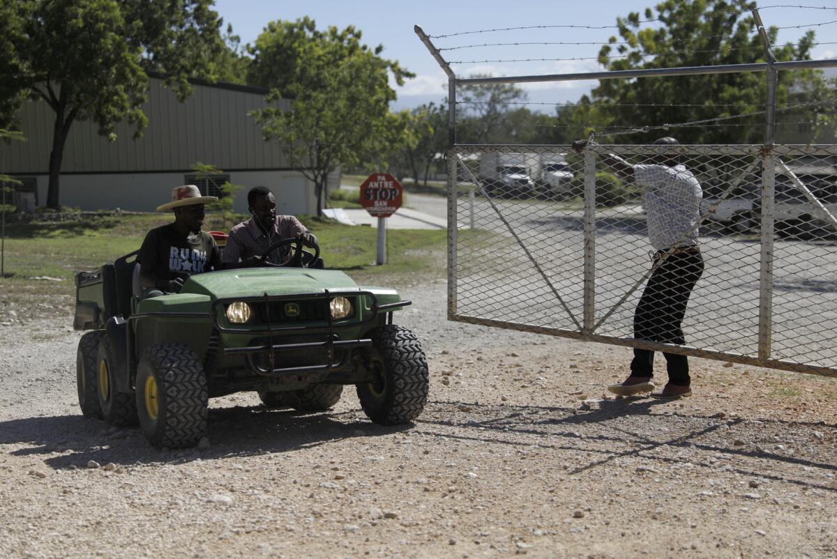 Workers ride out of the gate of the Christian Aid Ministries headquarters in Titanyen, north of Port-au-Prince, Haiti.