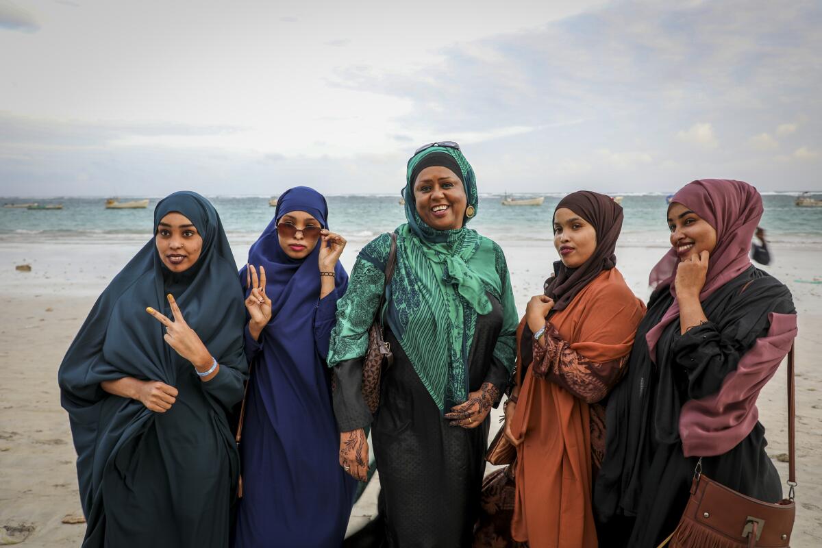 Somali Parliament member Fawzia Yusuf H. Adam, center, chats with campaign supporters at Lido beach in Mogadishu, Somalia Monday, July 19, 2021. The woman who broke barriers as the first female foreign minister and deputy prime minister in culturally conservative Somalia now aims for the country's top office as the country moves toward a long-delayed presidential election. (AP Photo/Farah Abdi Warsameh)