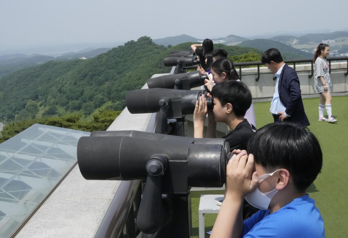 South Korean students looking through scopes trained at North Korea