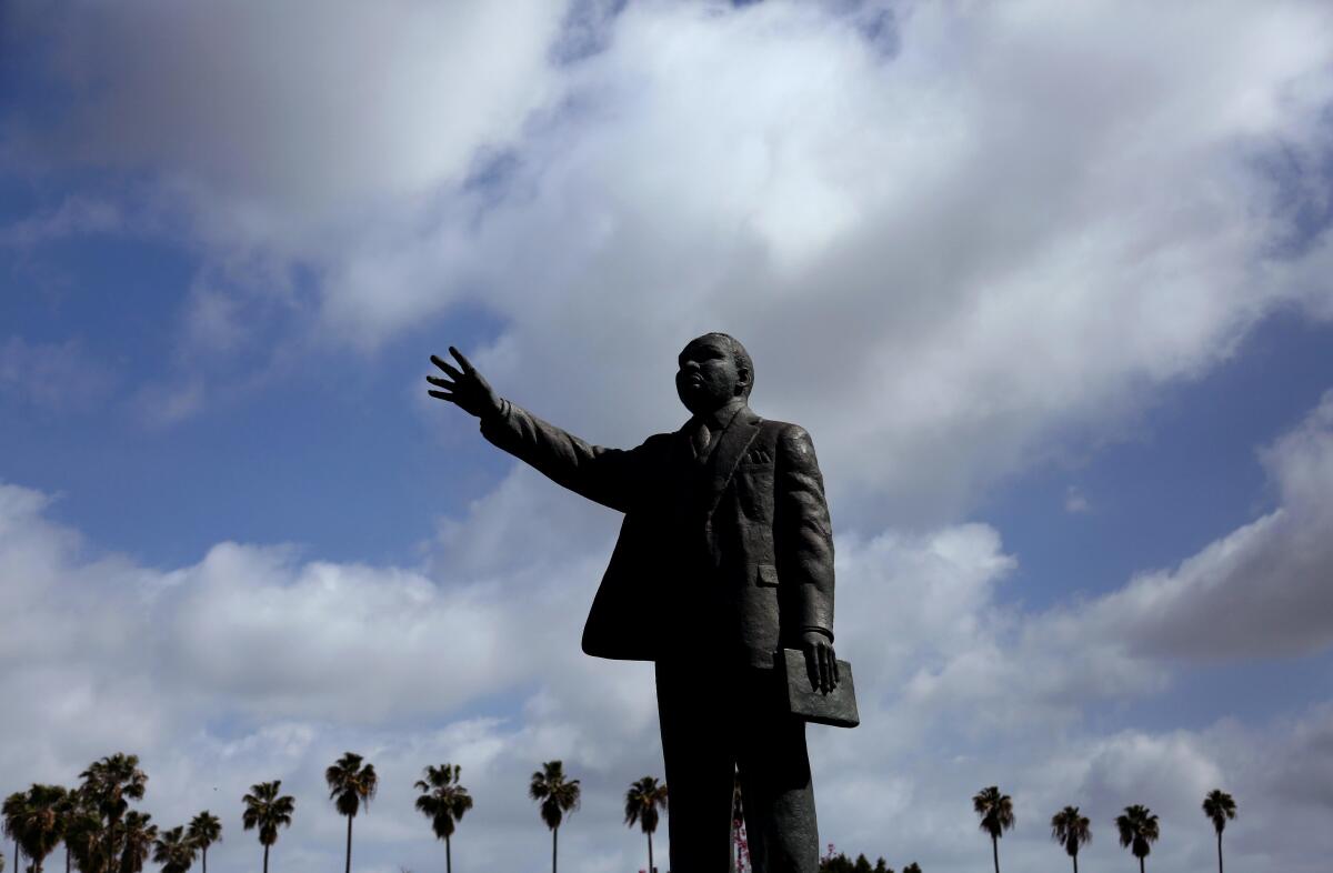 Palm trees surround a statue of Martin Luther King Jr. in Long Beach. The city has adopted a strict visitation policy limiting those who can enter nursing and long-term care facilities, mandating face coverings and requiring daily temperature screenings for staff and residents.