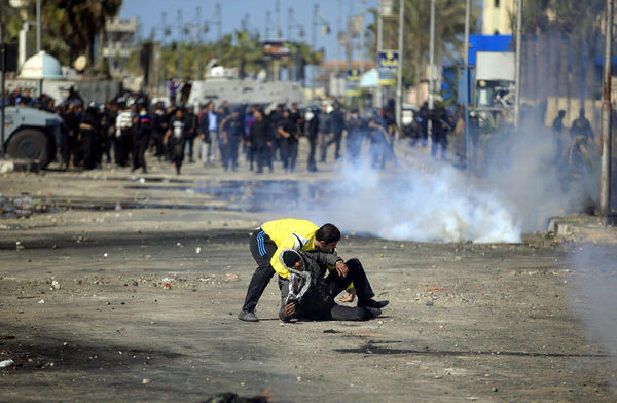 An Egyptian protester evacuates a wounded man during clashes with riot police near the state security building in Port Said, Egypt, on Wednesday.