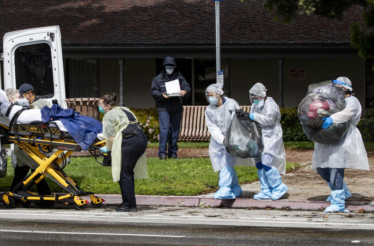 Medical staff carry a patient's belongings as she is evacuated from Magnolia Rehabilitation and Nursing Center last month.