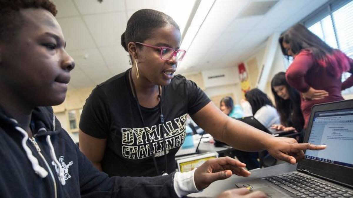 LaTeira Haynes, a la derecha, ayuda al estudiante de segundo año Anthony Rush durante la clase de ciencias biomédicas en Dymally High School, en Los Ángeles, el mes pasado.