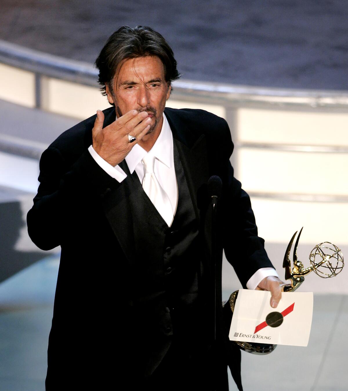 Al Pacino holds his Emmy in one hand and blows a kiss to the audience with the other at the 2004 Emmy Awards.