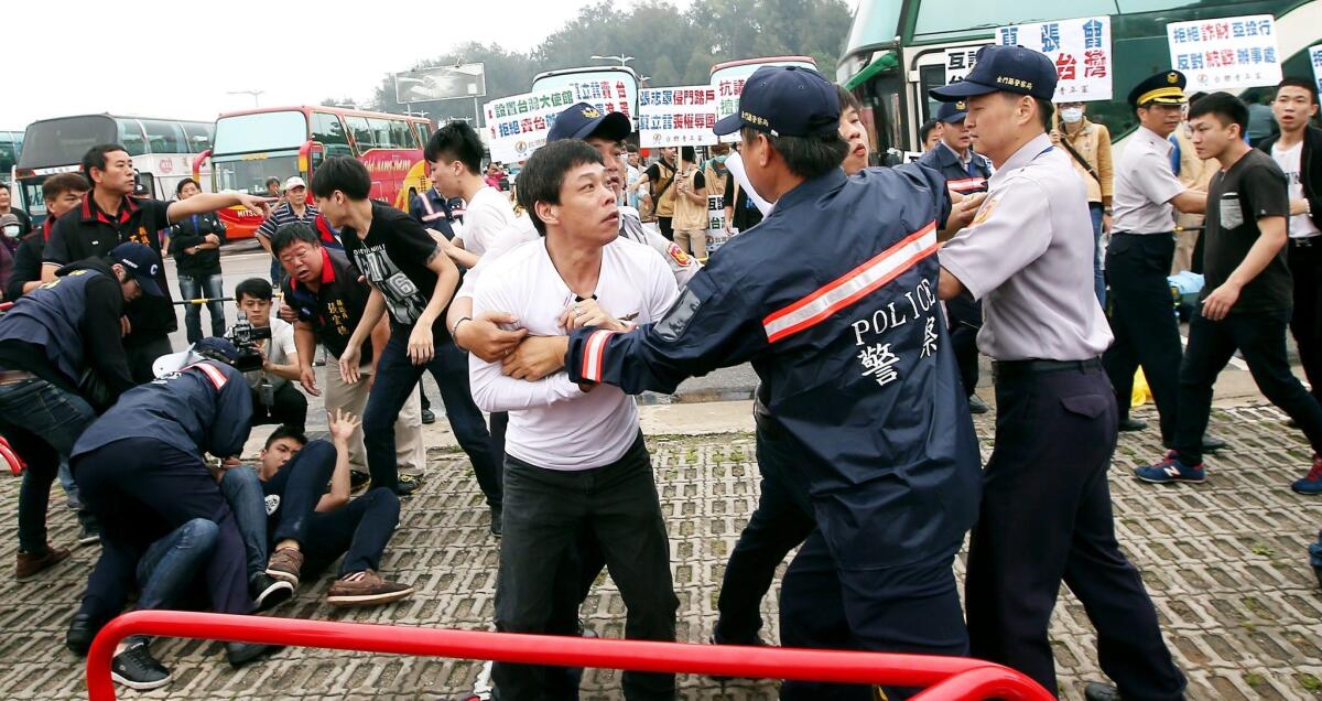 Anti-unification protesters clash with police as Chinese negotiators hold talks in the Golden Lake Hotel on Kinmen Island on Saturday.