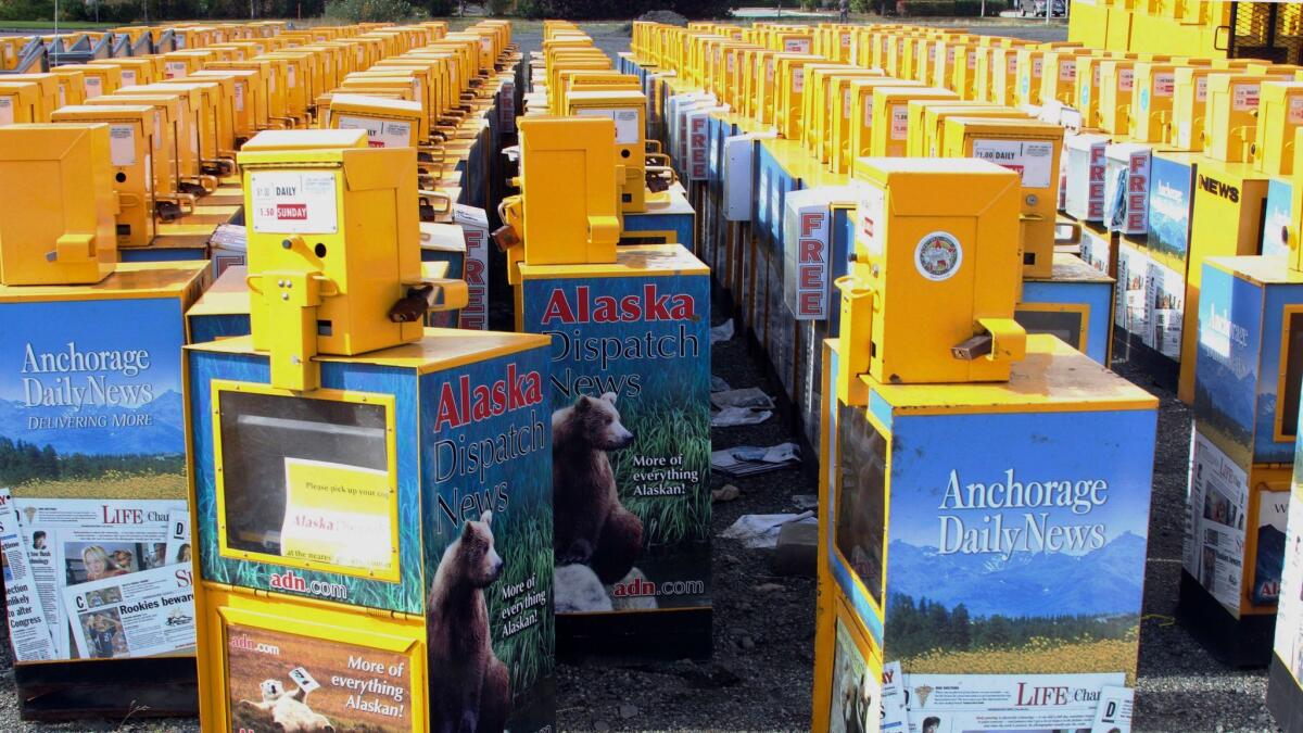 Hundreds of old newspaper sales boxes are shown Monday in a vacant lot near the former offices of the Alaska Dispatch News in Anchorage.