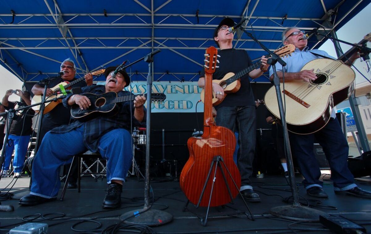 Los Lobos members Louie Pérez (second from right) and David Hidalgo (far right) are shown performing at the 2013 Adams Avenue Unplugged festival with Los Alacranes members Ricardo Sanchez (far left) and Ramon "Chunky" Sanchez (second from left). The two bands first performed together in San Diego in the 1970s. Ramon Sanchez died in 2016.