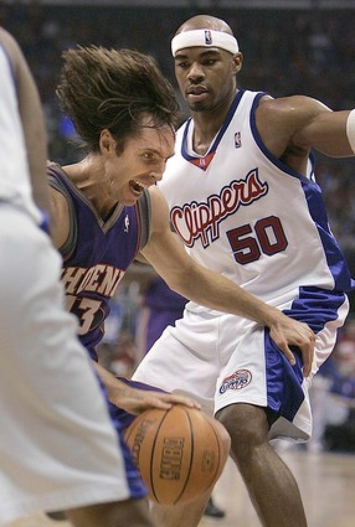 Los Angeles Clipper Corey Maggette tightly defends a driving Steve Nash.