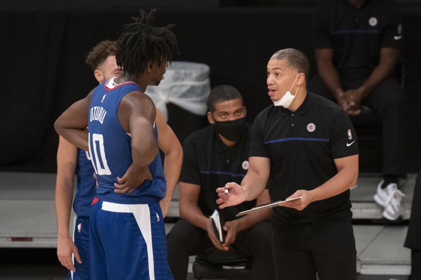 Los Angeles Clippers head coach Tyronn Lue, right, gives instructions to forward Daniel Oturu and guard Jordan Ford during an NBA preseason basketball game against the Los Angeles Lakers in Los Angeles, Friday, Dec. 11, 2020. (AP Photo/Kyusung Gong)