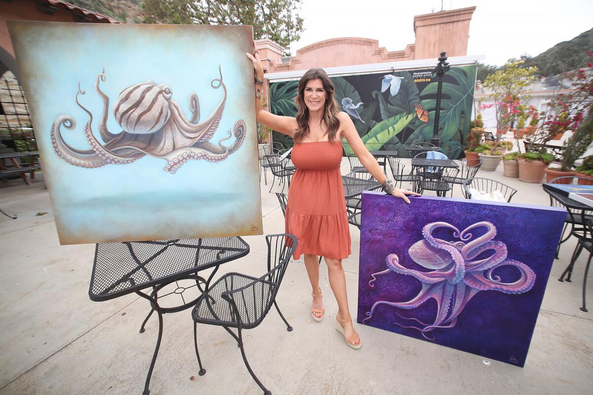 Debbie Avoux-Davis, a first-time exhibitor at the Laguna Art-A-Fair, stands with two of her octopus paintings.