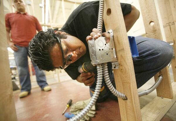 Juan Rodriguez, 18, works on an electrical box.