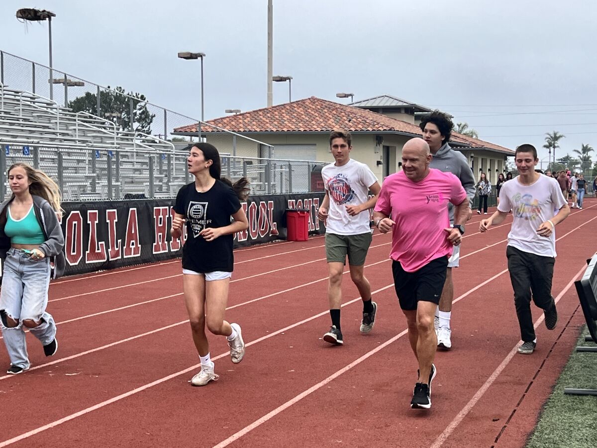 La Jolla High School teacher and coach Tom Atwell (in pink shirt) makes his 100-mile run in 2022. 