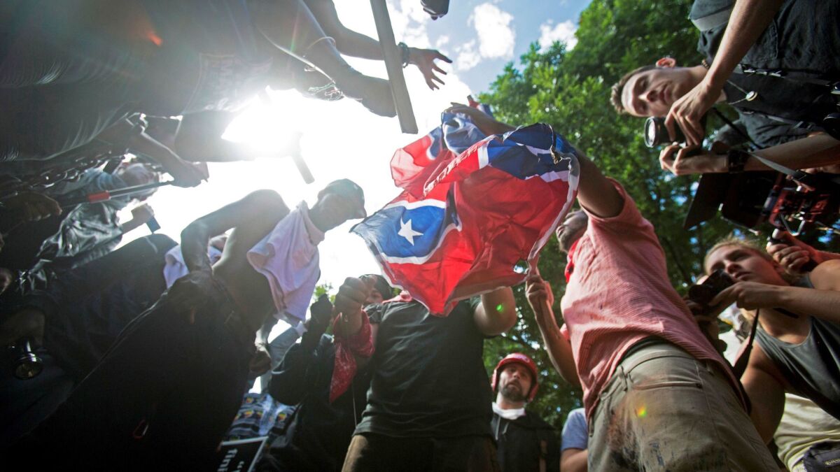 Counter-protesters tear a Confederate flag during a white nationalist rally in Charlottesville, Va. on Aug. 12.