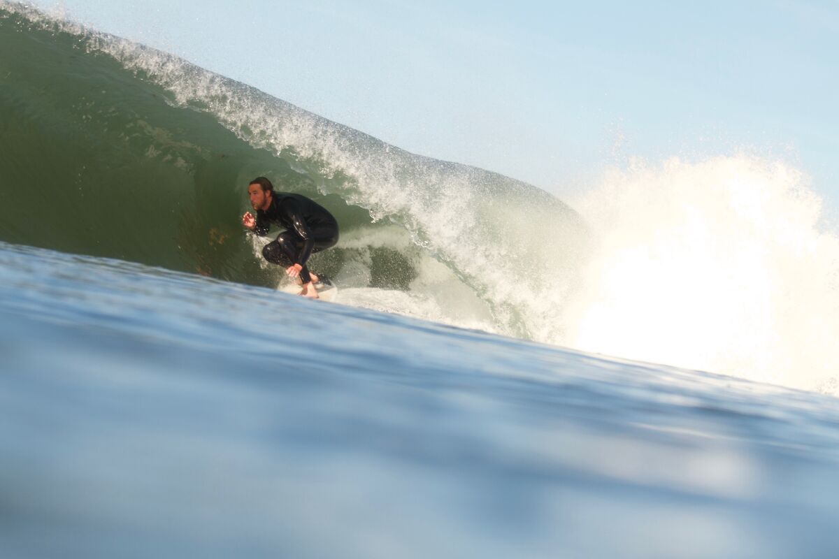 A surfer rides a tube off Ocean Beach.