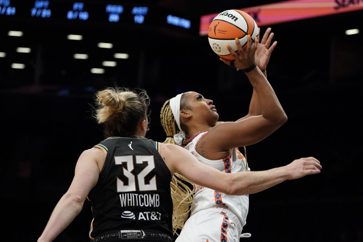 Connecticut Sun guard DiJonai Carrington (21) shoots against New York Liberty guard Sami Whitcomb (32) in the second half during a WNBA basketball game, Tuesday, May 17, 2022, in New York. (AP Photo/John Minchillo)