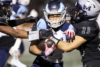 San Diego, CA - September 23: Granite Hills' Isaiah Jackson (1) is brought down by Madison's Allen Sola (23) during their game at Madison High School on Friday, Sept. 23, 2022 in San Diego, CA. (Meg McLaughlin / The San Diego Union-Tribune)