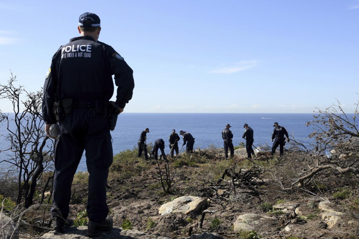 Police search a headland May 12 in Sydney following an arrest tied to the death of American Scott Johnson in 1988. 