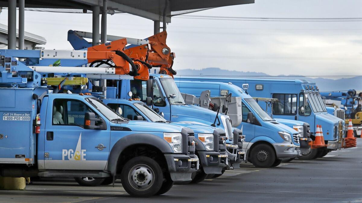 Light-blue PG&E vehicles lined up in a parking lot