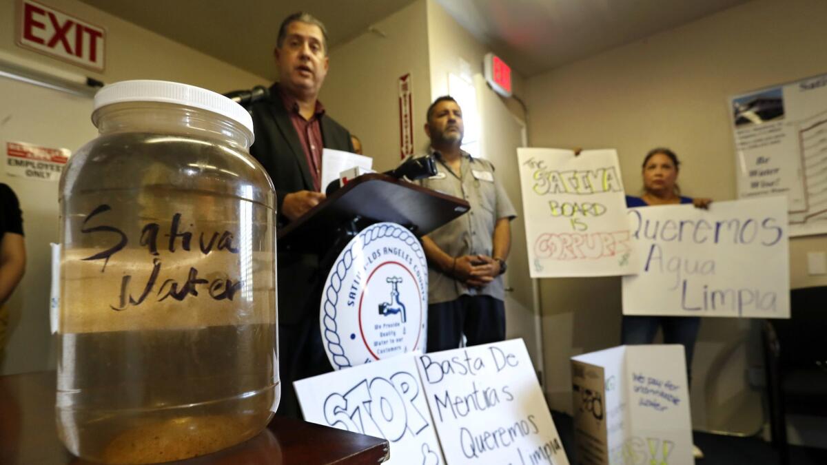 Thomas Martin, left, general manager of the Sativa Los Angeles County Water District, addresses the media this week during a news conference at the district's headquarters in Compton.