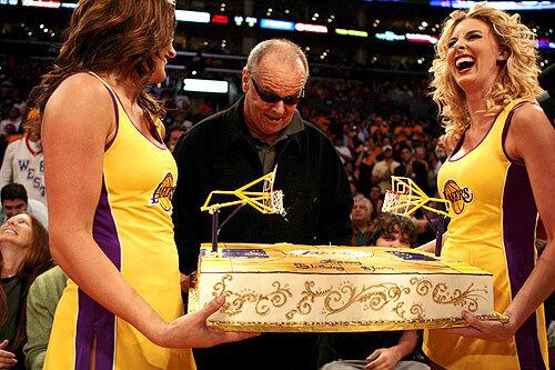 Laker Girls present Jack Nicholson with a birthday cake during a playoff game.