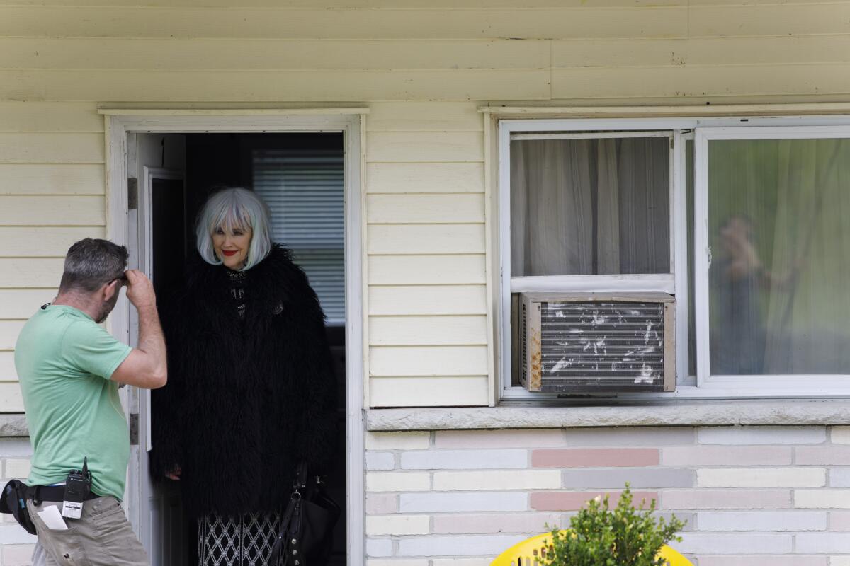 Catherine O'Hara peers out of a doorway between takes on the set of "Schitt's Creek."