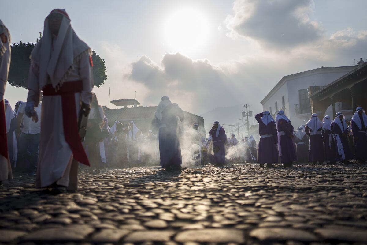 Penitentes llamados cucuruchos queman incienso al inicio de la Semana Santa en Antigua