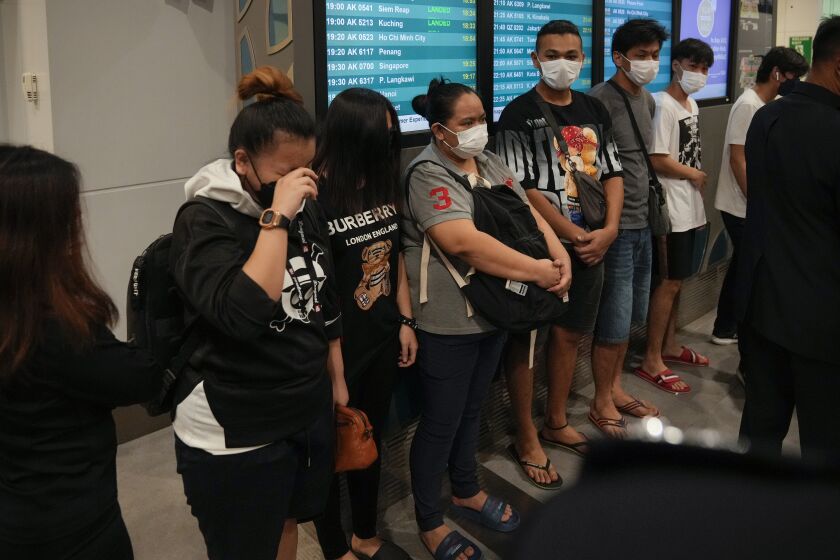 Malaysian youths rescued from human traffickers in Cambodia arrive at the Kuala Lumpur Airport Terminal in Sepang, Thursday, Oct. 6, 2022. Another 21 Malaysians rescued from human traffickers in Cambodia and Laos returned to the country Thursday, as the government intensified effort to detect scam victims stranded abroad. (AP Photo/Vincent Thian)