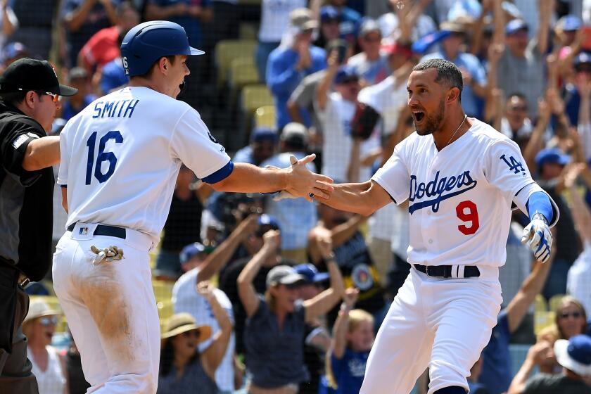 LOS ANGELES, CA - AUGUST 07: Kristopher Negron #9 celebrates after Will Smith #16 scored the winning run on a two RBI walk-off single by Russell Martin #55 of the Los Angeles Dodgers against the St. Louis Cardinals in the ninth inning at Dodger Stadium on August 7, 2019 in Los Angeles, California. (Photo by Jayne Kamin-Oncea/Getty Images)