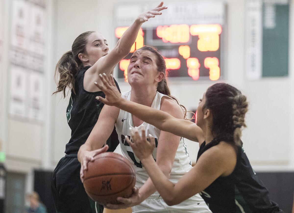 Sage Hill's Emily Eadie goes up against Ridgecrest Burroughs' Savannah Rowland, left, and Letty Sepulveda on June 2.