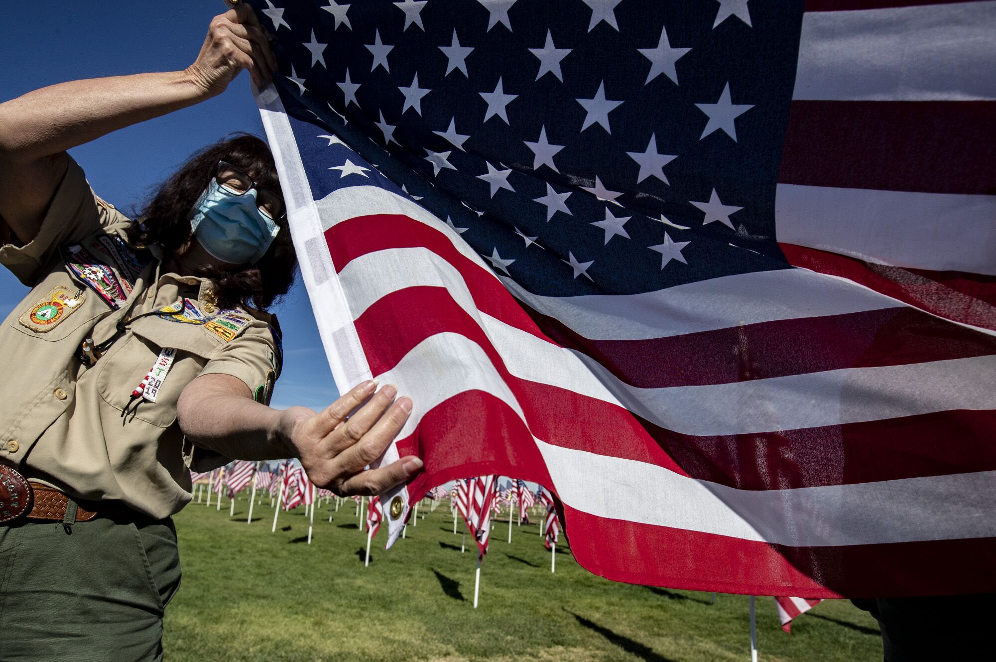 Colleen Metzger folds one of 2,020 American flags at the Palmdale Healing and Honor Field at Pelona Vista Park in Palmdale