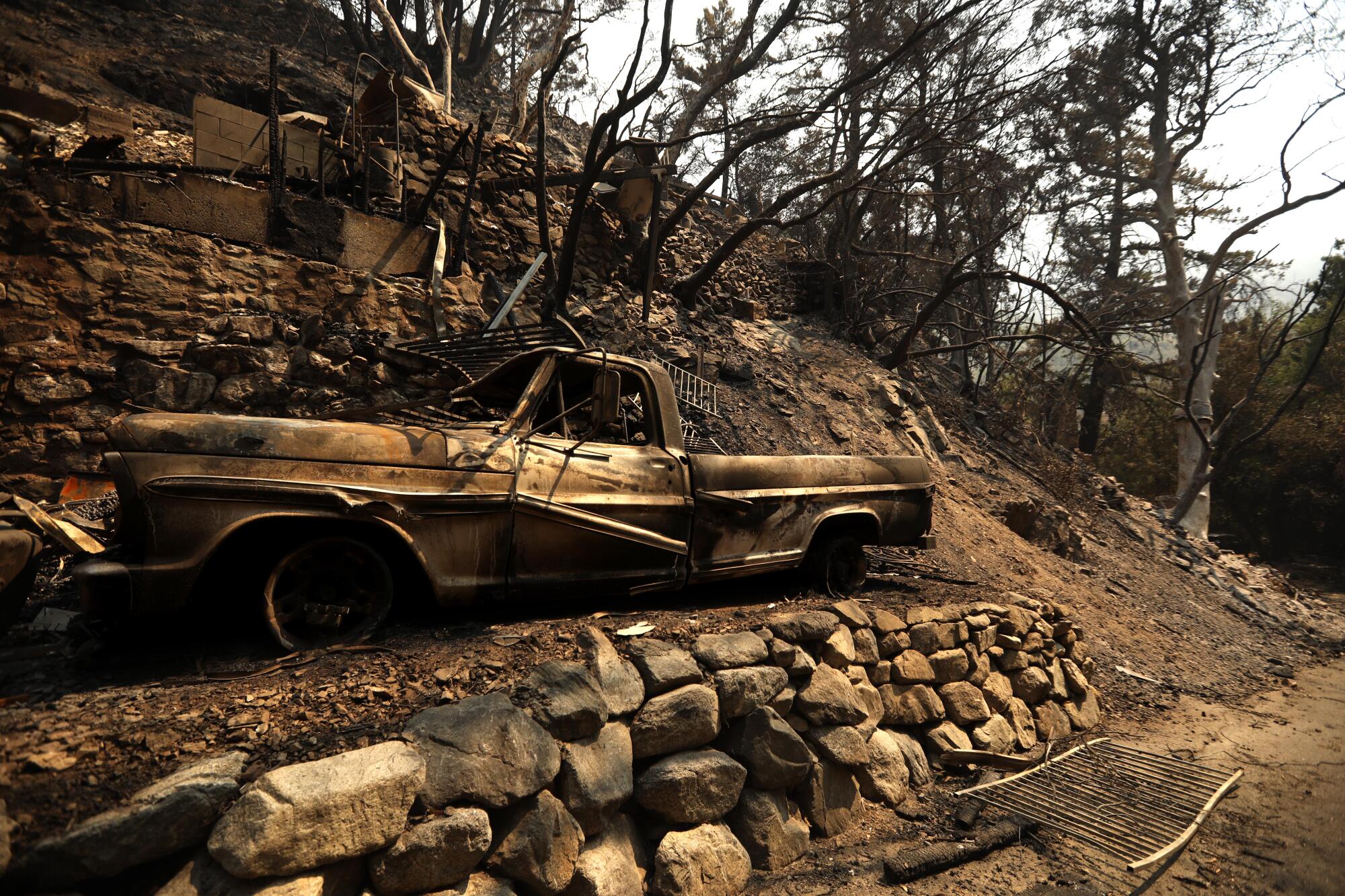 A fire ravaged car rests along Bear Canyon Road destroyed in the Bridge fire in Mount Baldy.