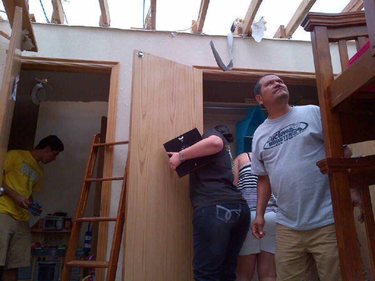 Edmundo Jaimes surveys the tornado damage at his house.