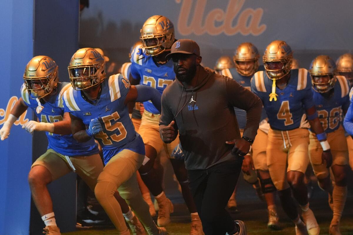 UCLA head coach DeShaun Foster leads his team onto the field before an NCAA college football.