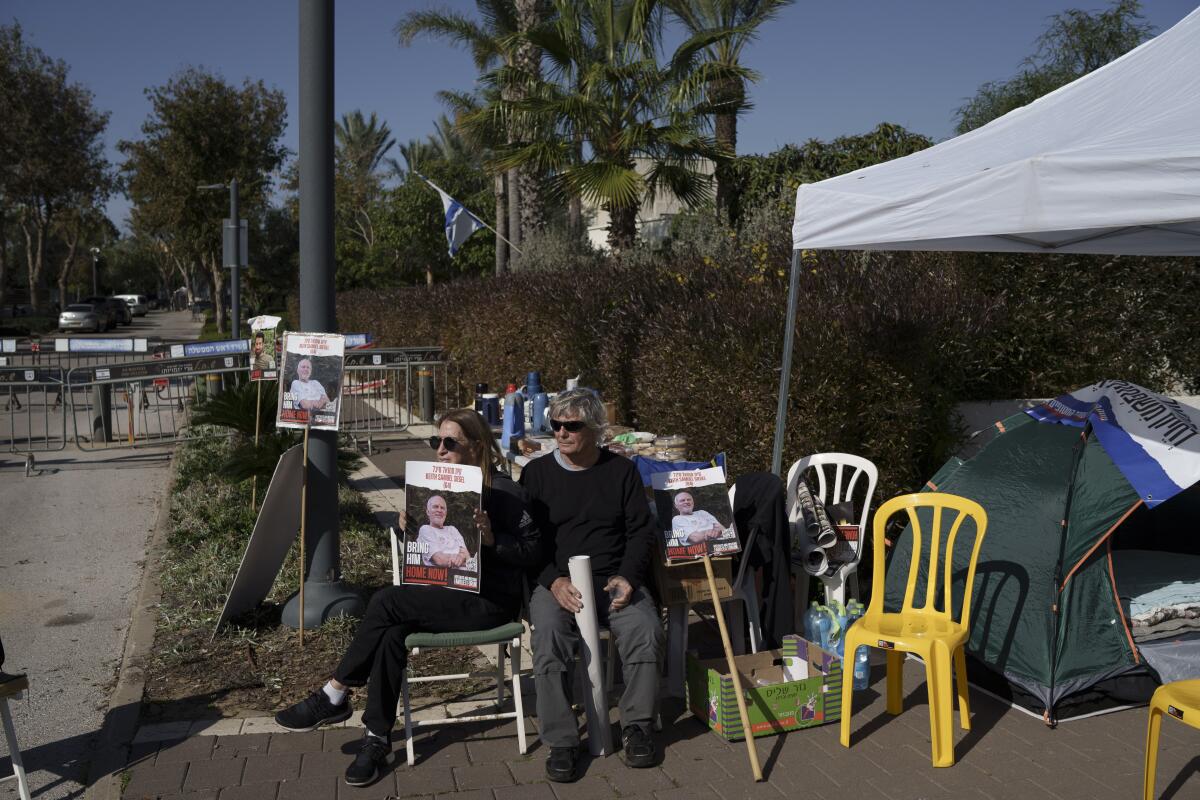 Familiares y amigos de los rehenes retenidos en Gaza, sentados en un campamento 