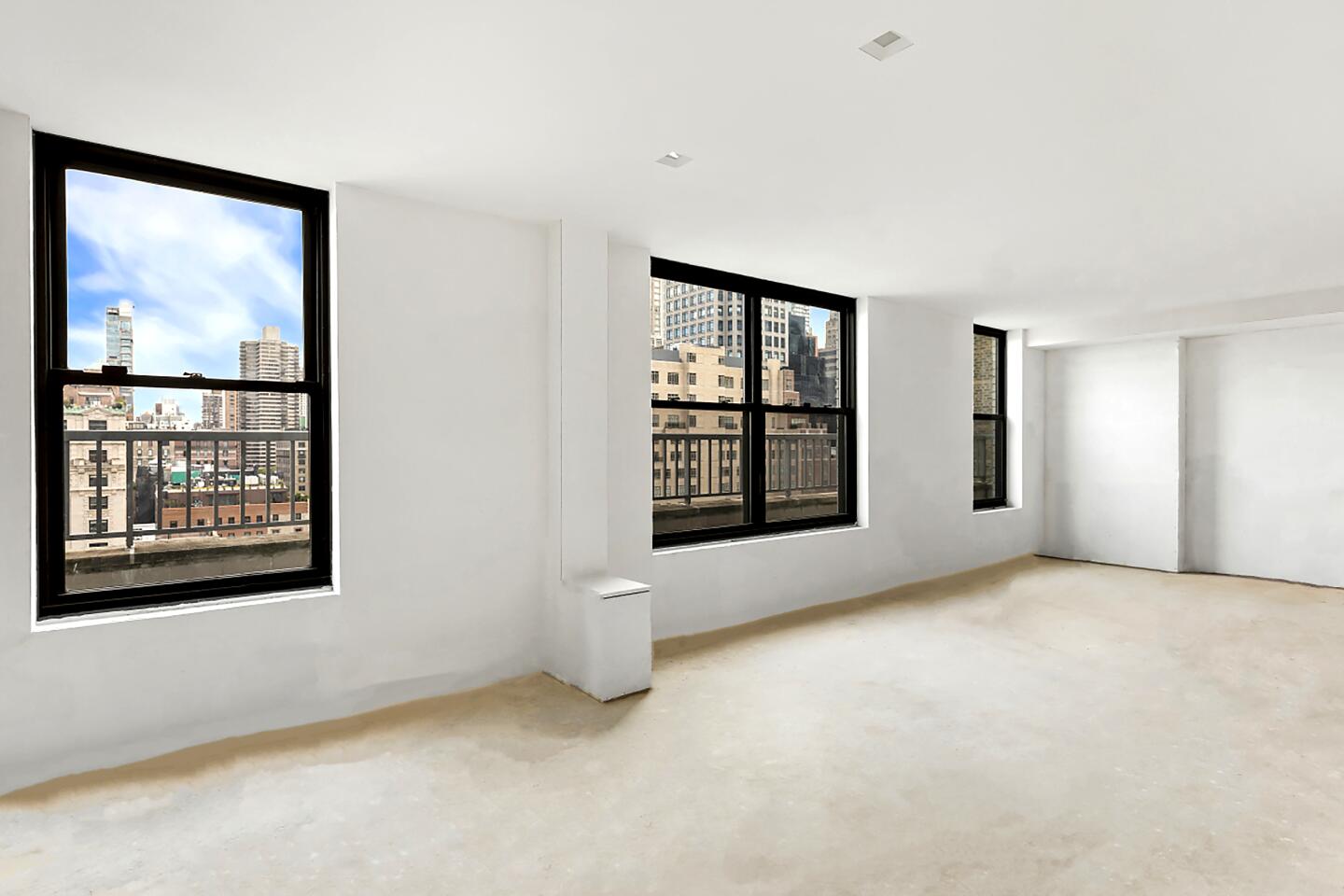 A carpeted room in the apartment with window views