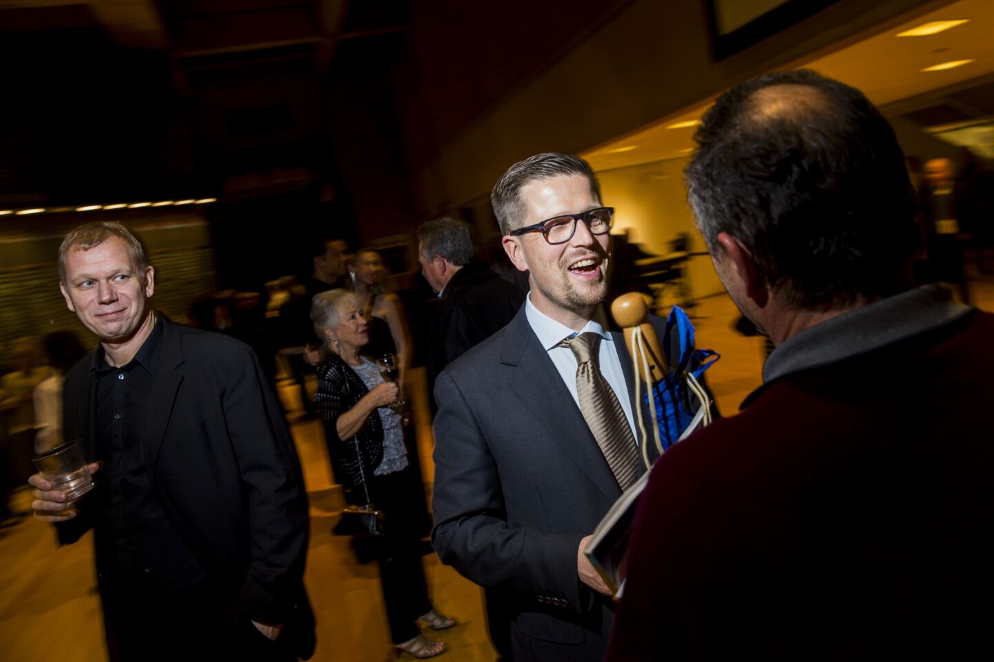 Producer Kai Nordberg, left, and director Klaus Härö greet movie fans at a party after the premiere of Härö's film "The Fencer."