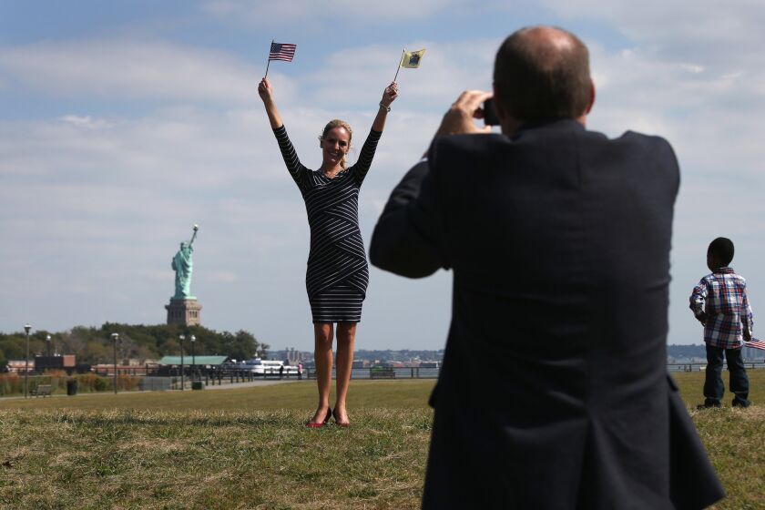 Nicole Annete Flood from Mexico poses in front of the Statue of Liberty following a naturalization ceremony at Liberty State Park in Jersey City, New Jersey.