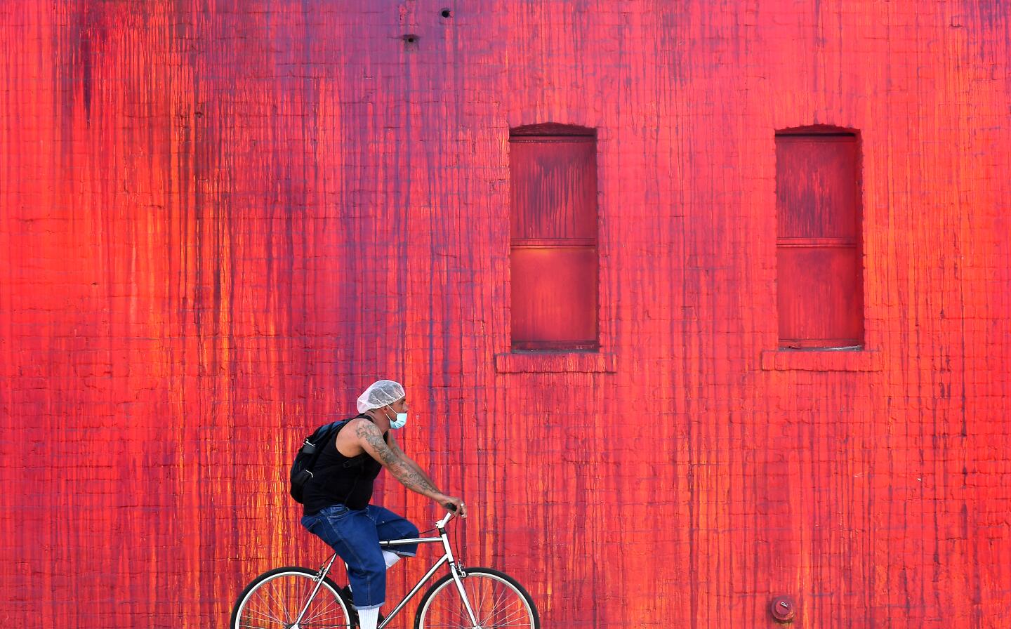 A man rides his bike through the Arts District in downtown Los Angeles.