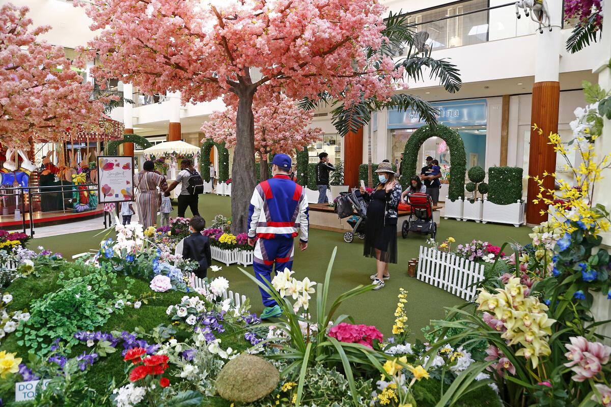 Families enjoy "Springtime Gardens" in Carousel Court on Friday as South Coast Plaza celebrates the start of spring.